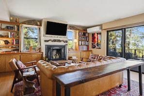 A cozy living room with a fireplace, a large sofa, a television, and a bookshelf. - Amethyst Ridge- A True Gem! (Prescott)