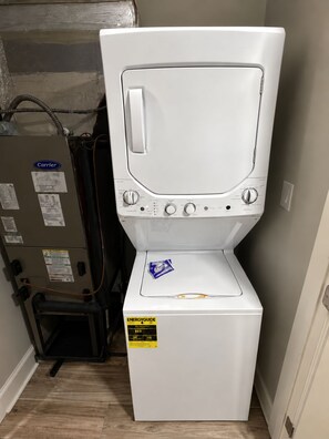 A white laundry machine with a control panel, a sticker indicating ENERGYGUIDE rating, and a small blue item on top. - Oceanfront 3BR  Balcony Bliss!  Park Close to Your Door (Myrtle Beach)