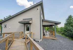 A modern building with a covered porch and a wooden deck. - Cozy Glamping Cabin #3 in Swanton (Swanton)