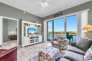 Een ruime woonkamer met een televisie, een open haard en een balkon met uitzicht.