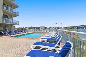 A poolside area with lounge chairs and a view of a river. - Palm Court Yacht Club 604 (Fort Walton Beach)