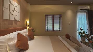 Habitación de hotel con una cama grande, una obra de arte en la pared, una ventana con persianas y un equipo de aire acondicionado.