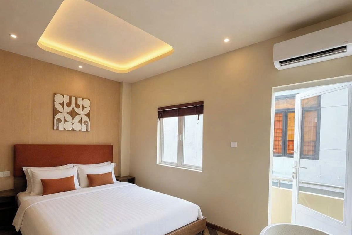 A modern hotel room with a large bed, a freestanding bathtub, and a window with a view.