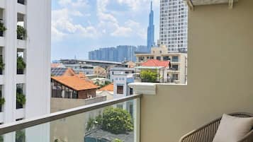 Un balcón con vistas a un paisaje urbano, incluyendo un edificio alto.