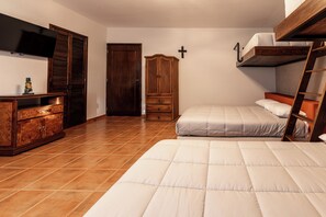 A bedroom with a bunk bed, a wooden wardrobe, a television, and a cross on the wall. - Spacious Home for 10 – 2 km from Peña de Bernal (Bernal)