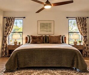 A bedroom with a bed, a ceiling fan, a window with curtains, and a wall-mounted picture. - Canyon & Sage Sedona Retreat (Sedona)