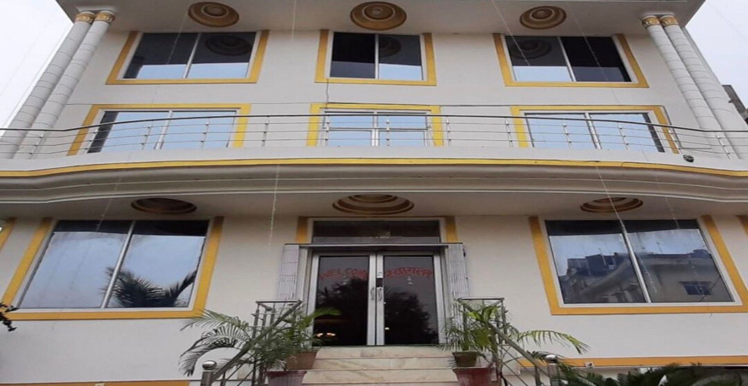 Un edificio de varios pisos con un balcón curvo, ventanas amplias y una entrada central.