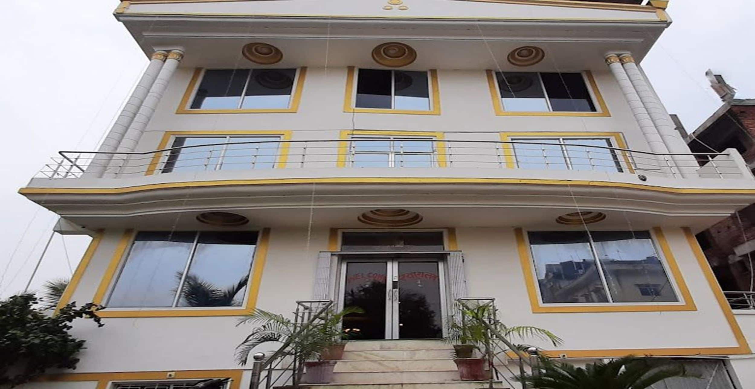A multi-story building with a balcony, large windows, and a central entrance.