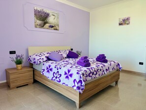 A bedroom with a bed, nightstands, a potted plant, and a wall-mounted artwork. - Casa Corbezzolo, Abruzzo (Abruzzo)
