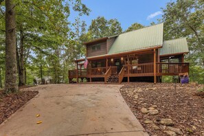 A two-story cabin with a covered porch and a stone pathway leading to the entrance. - Hot Tub • Game Room • 3 King Beds • Pet Friendly (Ellijay)