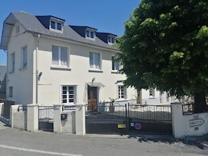 A two-story building with a gated entrance, a visible door, and a sign indicating 'BARLEST 07'.