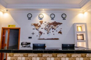 A reception desk with a world map and clocks indicating different time zones. - Belmont Hotel Mbale (Mbale)