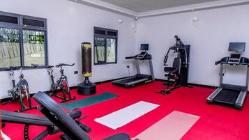Un gimnasio con diferentes equipos de ejercicio, como cintas de correr, un saco de boxeo y máquinas de pesas.