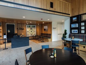 A reception area with a wooden interior, a reception desk, and a seating area with a bench and chairs. - PARQ Founders Place Ski In-Out Pool Fitness Yoga Sauna Game Room Private Hot Tub (Park City)