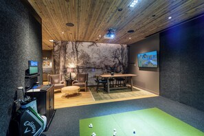 A room with a wooden ceiling, a green carpet, a table with chairs, a desk with a computer, and a wall with a painting. - PARQ Founders Place Ski In-Out Pool Fitness Yoga Sauna Game Room Private Hot Tub (Park City)