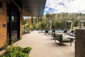 Ein modernes Gebäude mit Poolbereich, ausgestattet mit Liegestühlen und Sonnenschirmen.
