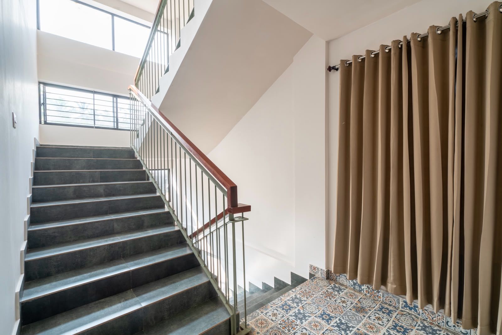 Una escalera con barandilla metálica y suelo estampado.
