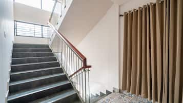A staircase with a metal railing and a patterned floor.
