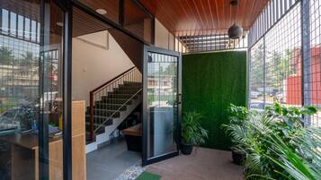 A modern interior with a staircase, a glass door leading outside, and a green wall.