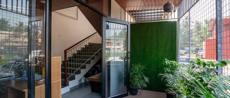 A modern interior with a staircase, a glass door leading outside, and a green wall.