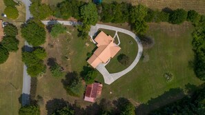 An aerial view of a property with a central building, a surrounding lawn, and a curved driveway. - Retreat at Delano | Near Hiwassee & Scenic Railway (Delano)