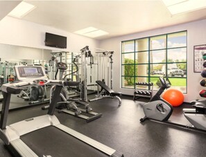 A gym with cardio machines, weightlifting equipment, and a large window with a view of the outdoors. - Cozy 1-bedroom condo in charming Scottsdale (Scottsdale)