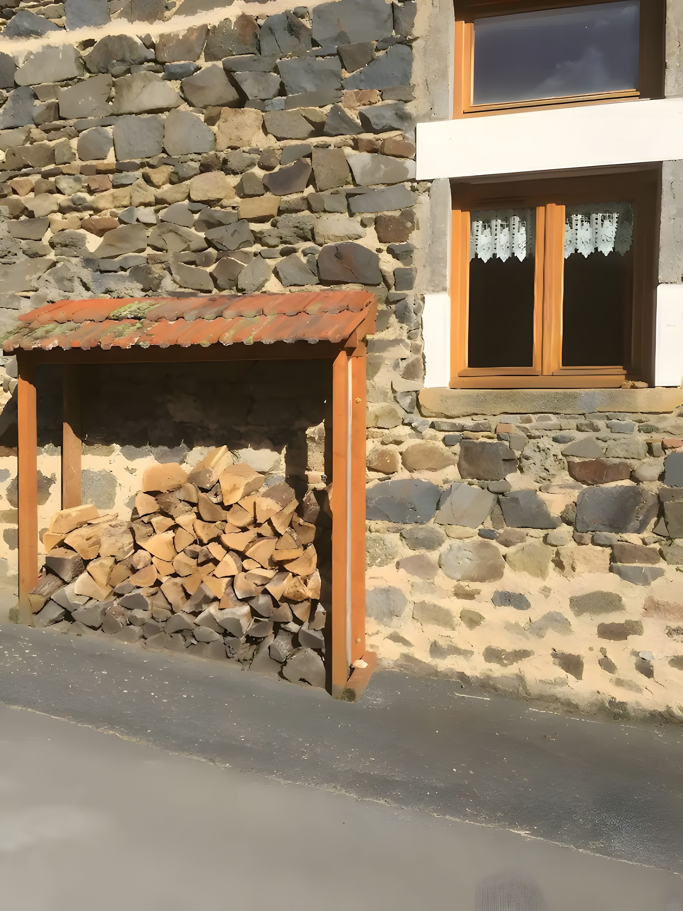 Un edificio de piedra con estructura de madera y una ventana con cortinas de encaje.