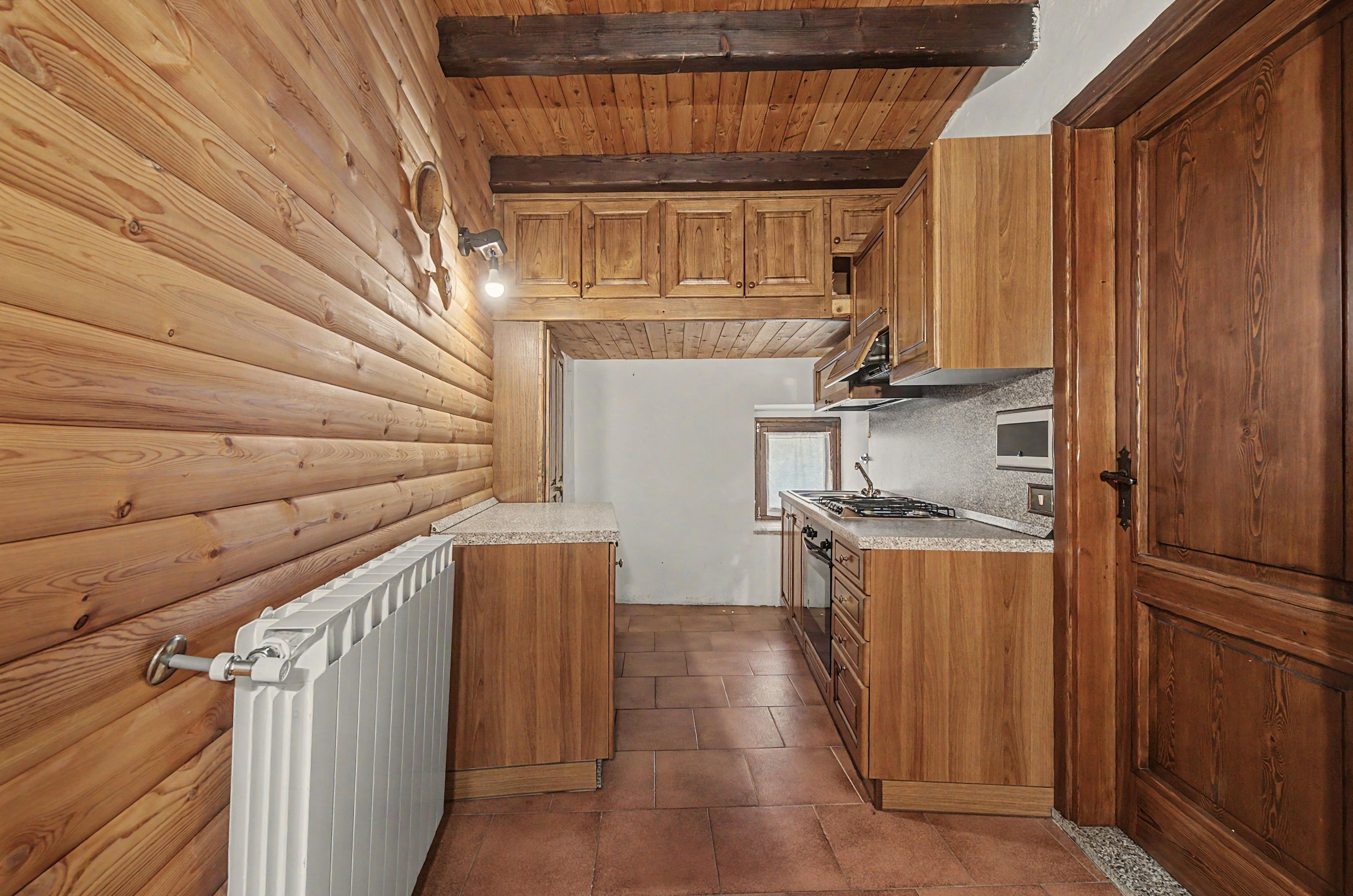 A compact kitchen with wooden cabinetry and a white countertop.