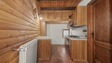 A compact kitchen with wooden cabinetry and a white countertop.