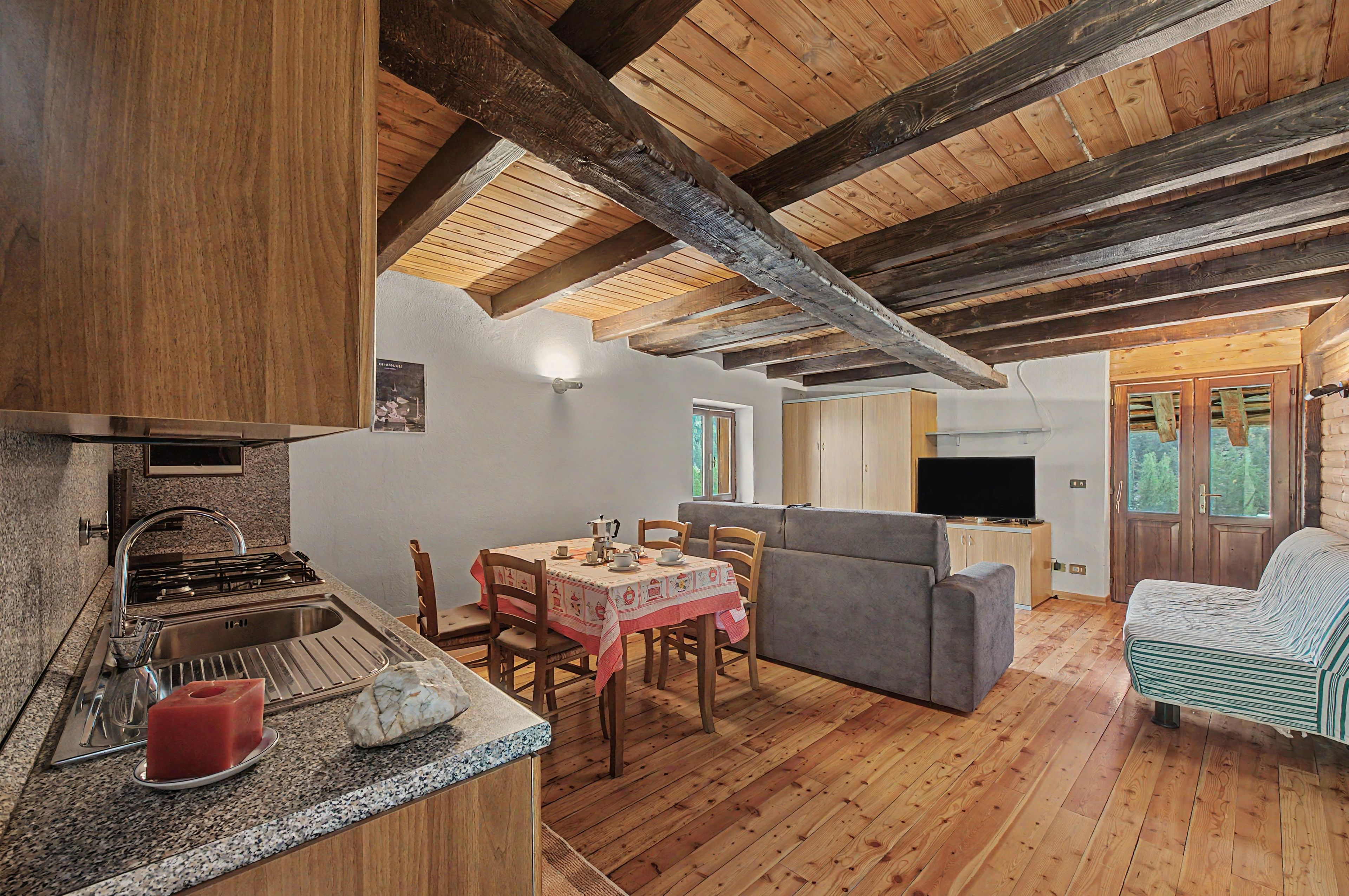 Ein gemütliches Blockhaus-Interieur mit Küche, Essbereich und Wohnbereich.