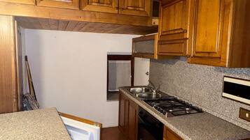 A kitchen with wooden cabinets, a built-in oven, and a countertop.
