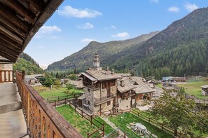 Un bâtiment traditionnel en pierre, doté d’un clocher, et entouré d’un paysage montagneux.