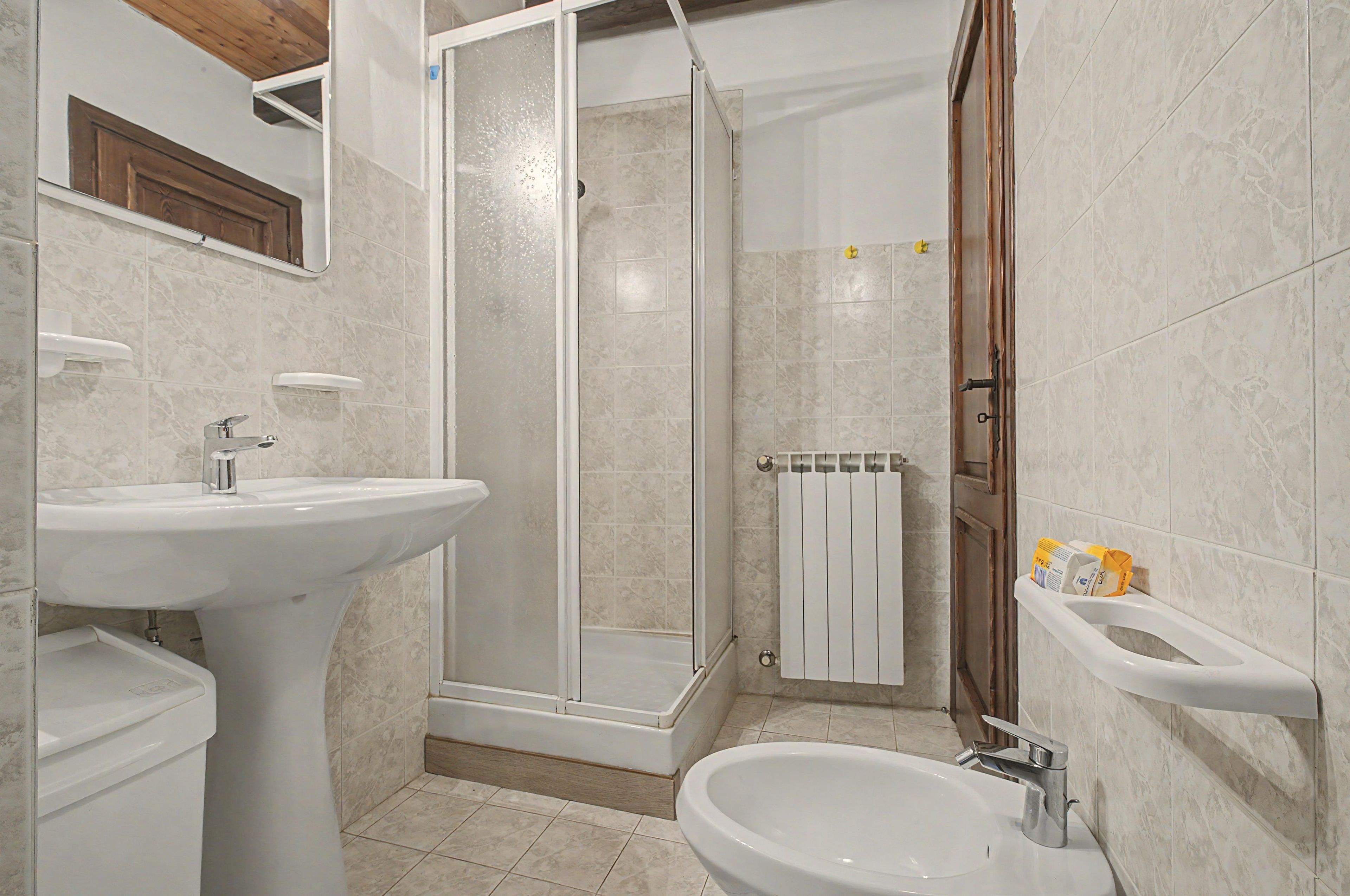 Ein Badezimmer mit Dusche, Waschbecken und Bidet.