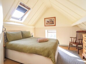 A bedroom with a bed, a chair, a dresser, a window, and a painting on the wall. - Pandy Farmhouse (Dolgellau)