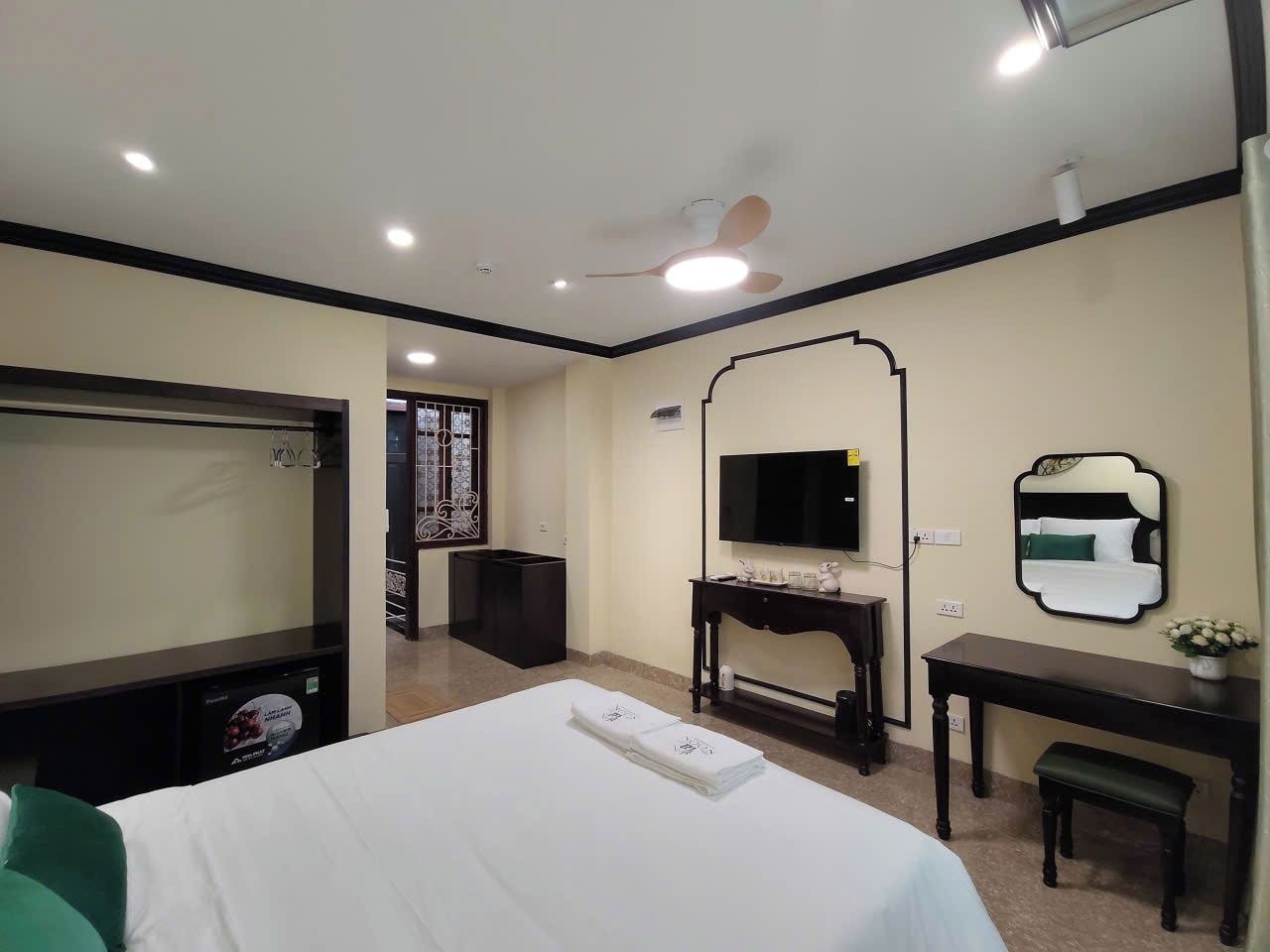 A hotel room with a bed, a desk, a television, and a mirror.