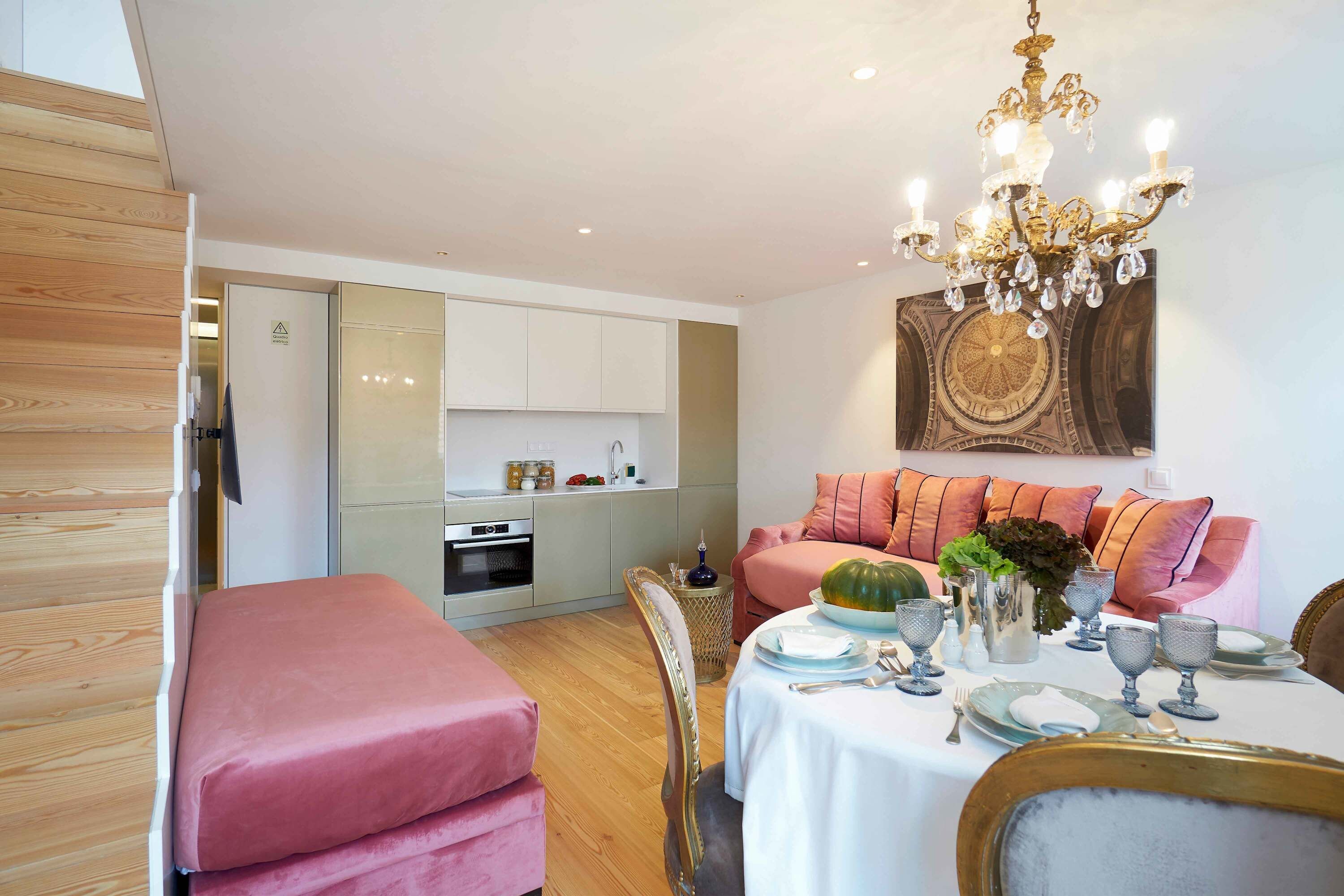 Ein modernes Interieur mit Essbereich, Küche und Wohnbereich inklusive Sofa und Kissen.