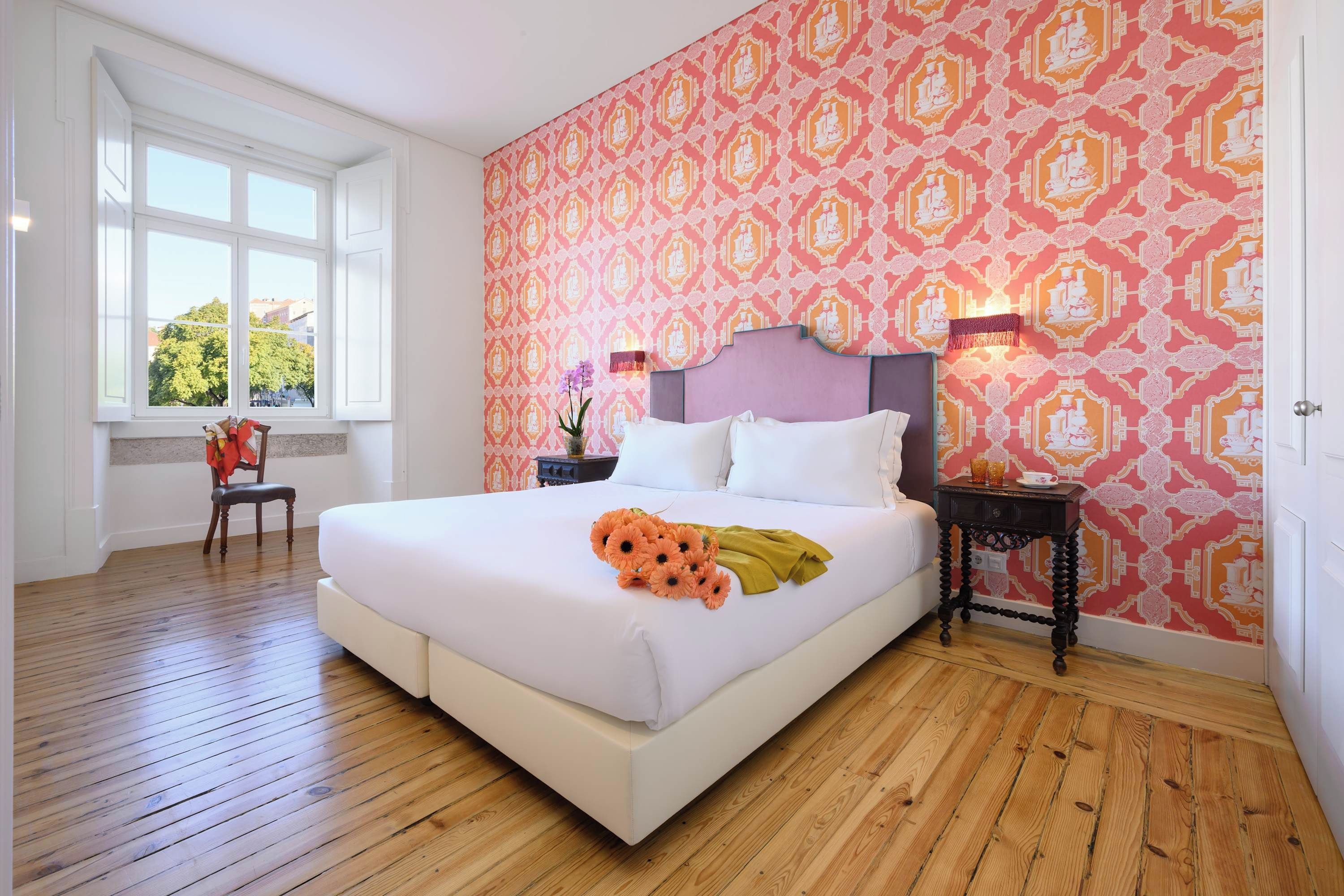 Ein Schlafzimmer mit einem großen Bett, einem Fenster und einer Wand mit Muster.