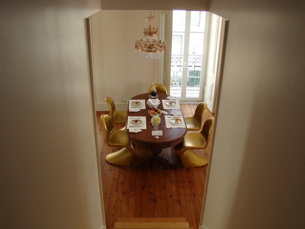 A dining area with a round table, chairs, and a chandelier.
