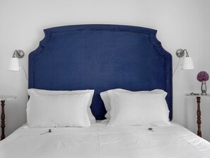 A bed with a blue upholstered headboard, white bedding, and two bedside lamps. - Lisbon Duplex Apartment with 2 Bedrooms & Balcony (Lisbon)