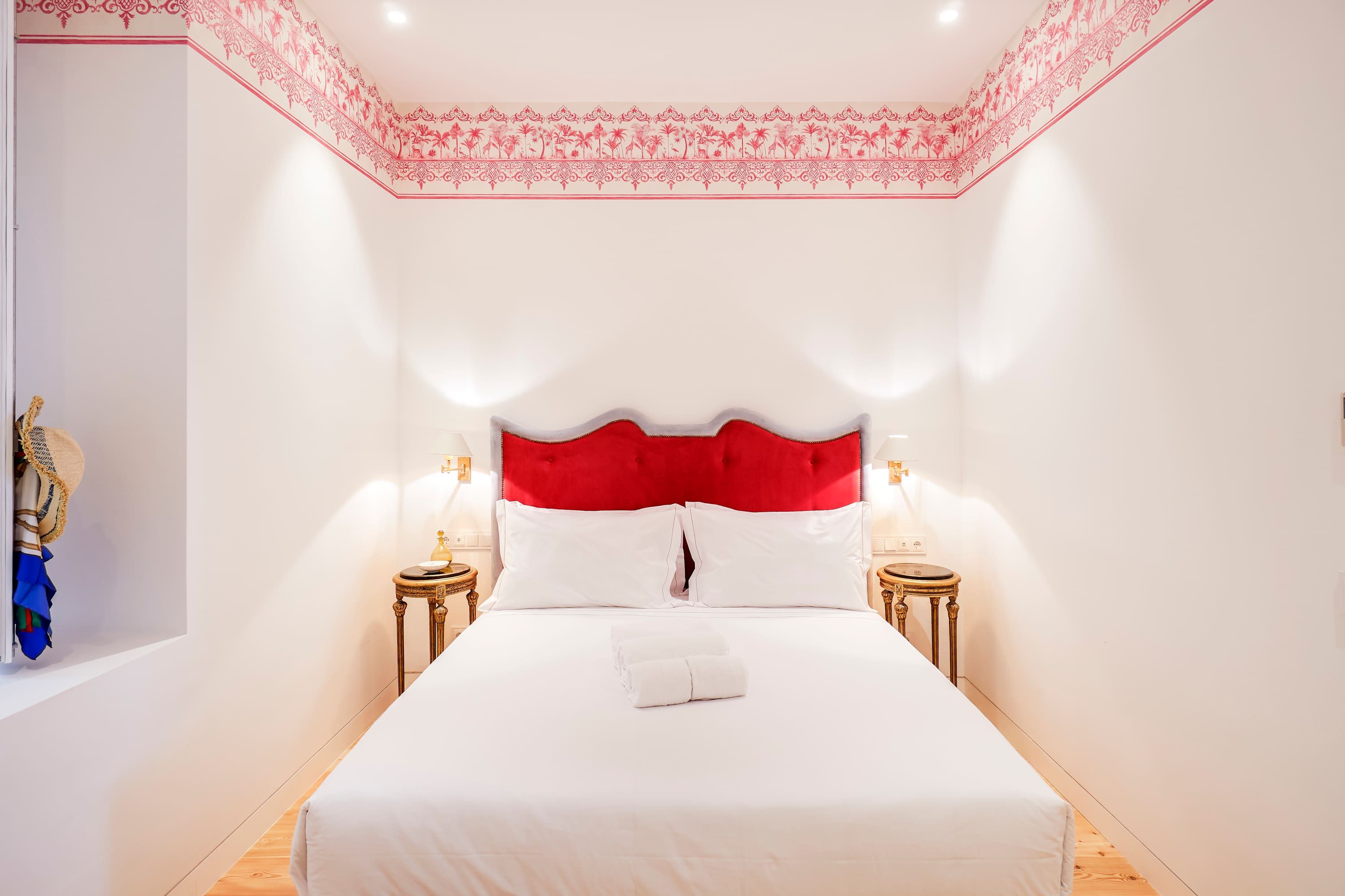 Ein Hotelzimmer mit einem großen Bett, zwei Nachttischen und einer dekorativen Decke.