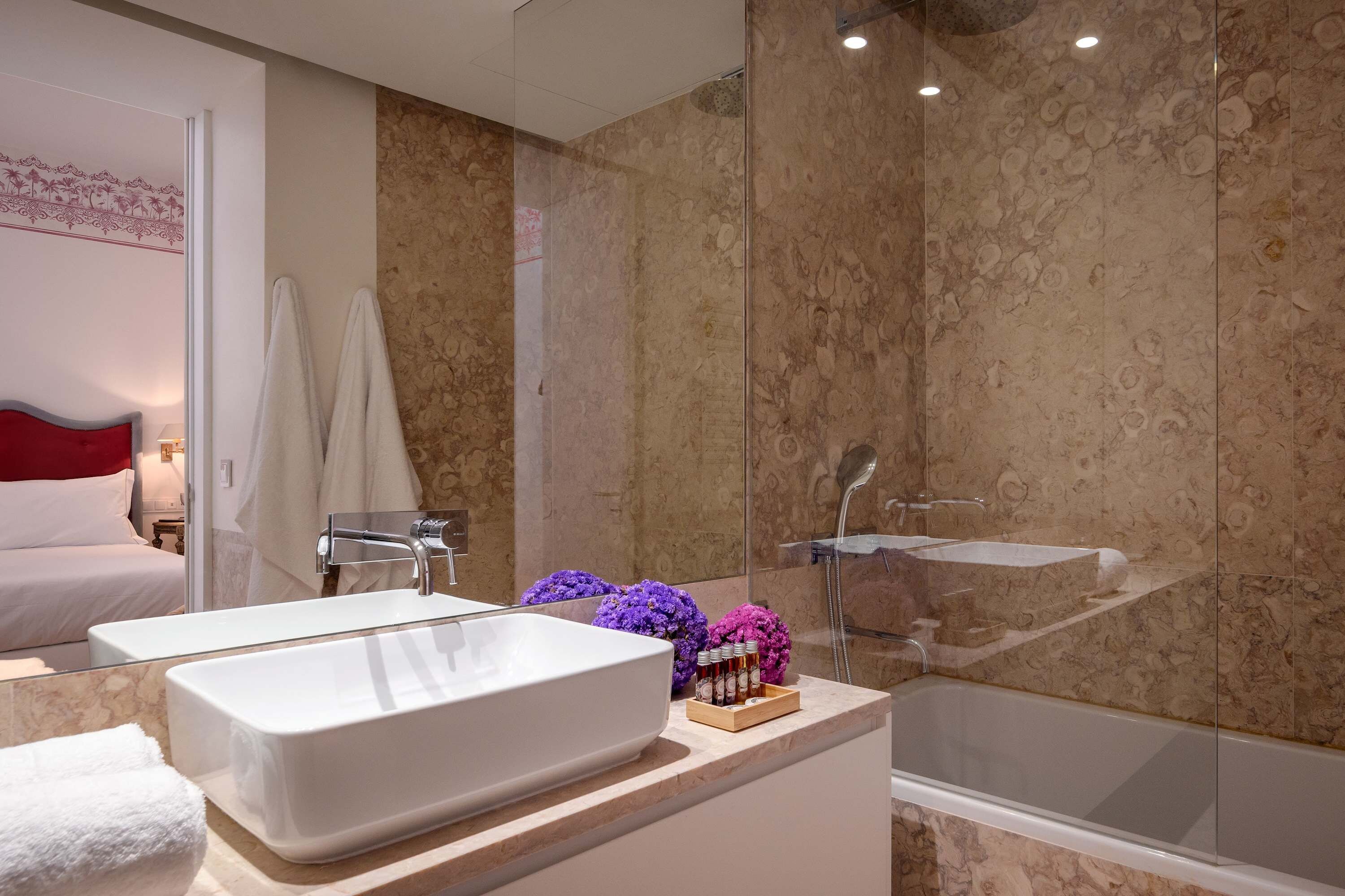 Un baño moderno con una bañera grande, una zona de ducha separada y un tocador con un lavamanos espacioso.