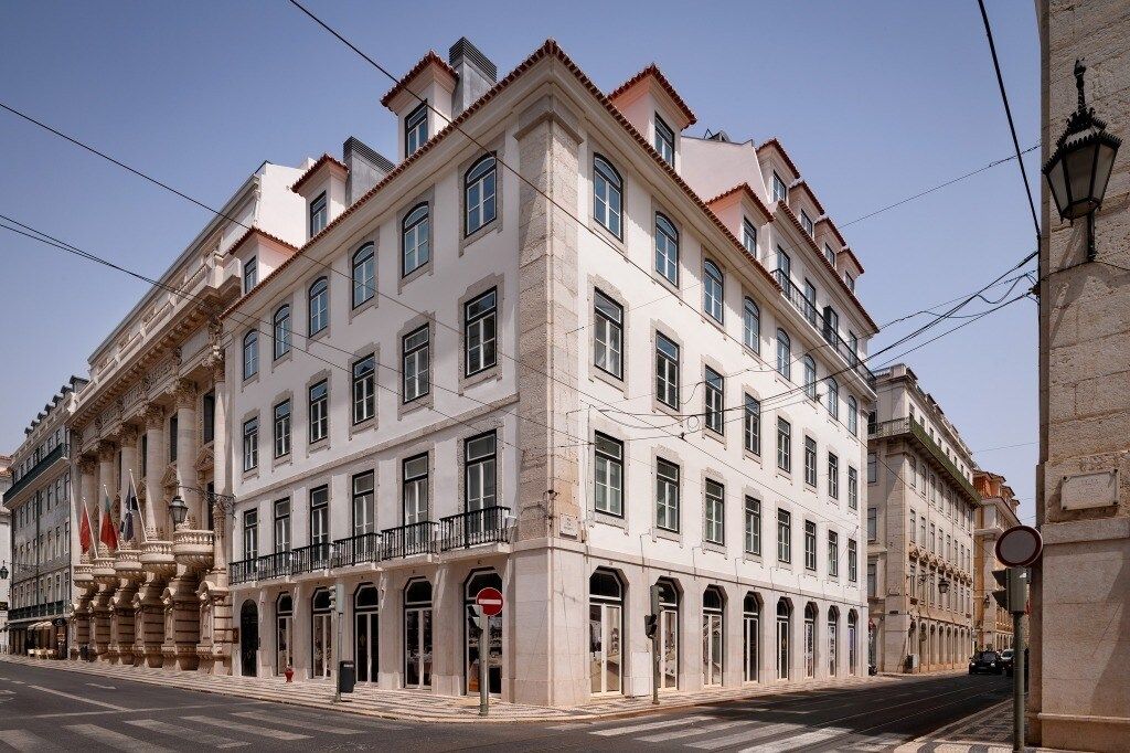 Um edifício histórico com vários andares, grandes janelas e estilo arquitetônico clássico.