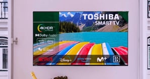 Pantalla mural que anuncia un televisor Toshiba Smart con 4K HDR y audio Dolby, mostrando los logotipos de Netflix, Disney+, Prime Video y más.