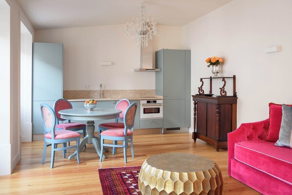 Uma sala de estar moderna com um sofá vermelho, uma mesa de centro redonda e um tapete estampado.