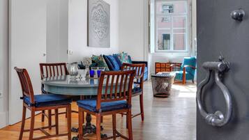 A dining area with a round table, wooden chairs, and a blue cushioned bench.