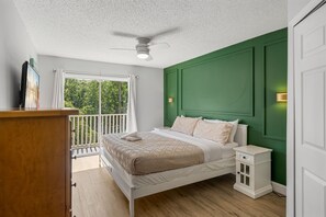 A bedroom with a bed, nightstand, and a ceiling fan. - Emerald Island Corner Townhome  2 King Suites (Kissimmee)