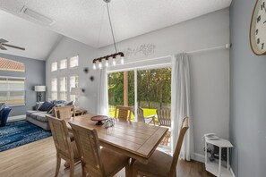 Ein modernes Wohnzimmer mit Essbereich, großen Fenstern und Blick ins Freie.