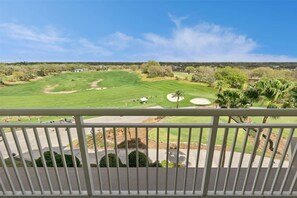 A golf course with a clear view of the fairway, sand bunkers, and a distant horizon.
