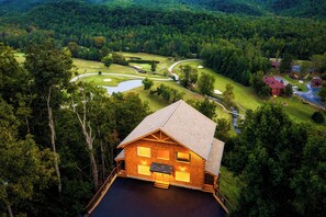 Eine Lodge mit einer großen Terrasse und Blick auf einen Golfplatz.