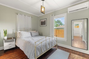 A bedroom with a bed, bedside table, and a window. - The Nook on 4th Street (Prescott)